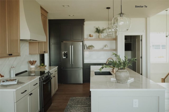 kitchen with white cabinets, stainless steel refrigerator with ice dispenser, custom exhaust hood, black range with electric stovetop, and pendant lighting