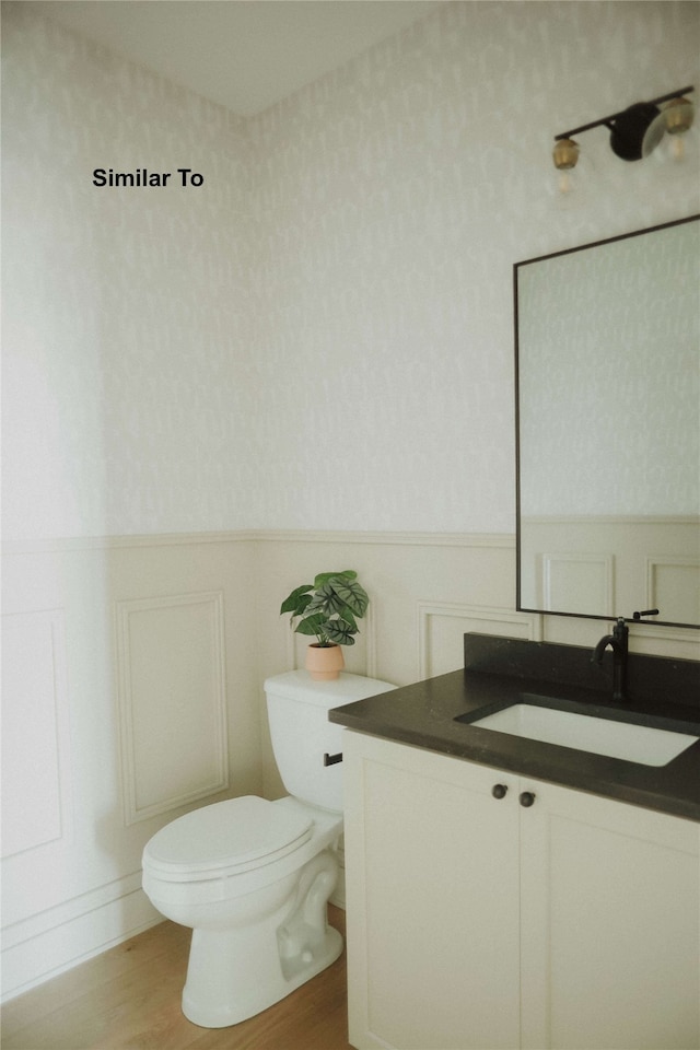 bathroom featuring vanity, hardwood / wood-style flooring, and toilet