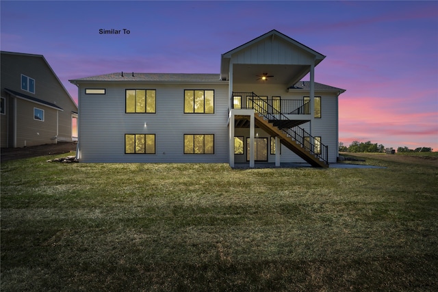 back house at dusk with a lawn and ceiling fan