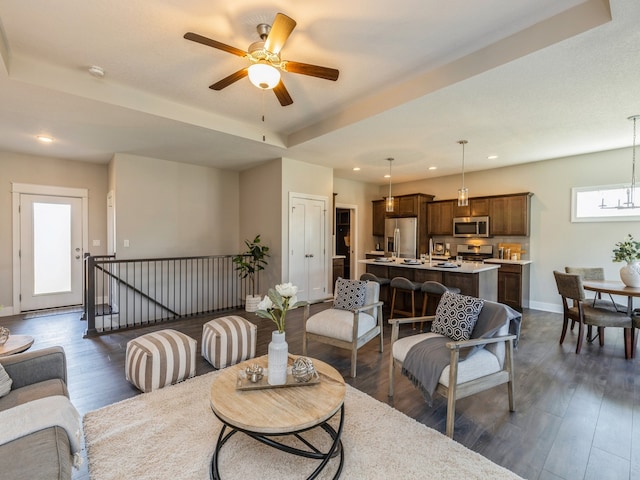 living room featuring dark wood-type flooring and ceiling fan