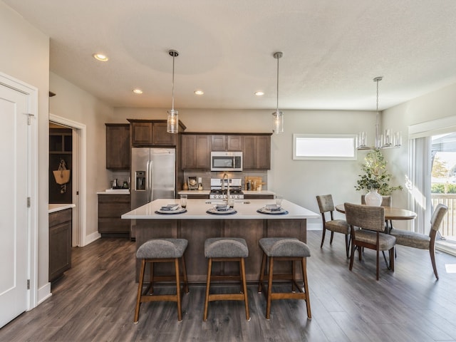 kitchen featuring hanging light fixtures, a center island with sink, and appliances with stainless steel finishes