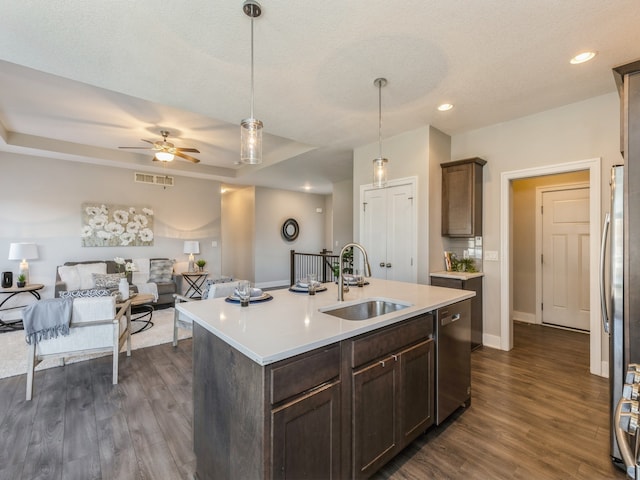 kitchen with dark hardwood / wood-style flooring, sink, a kitchen island with sink, and appliances with stainless steel finishes