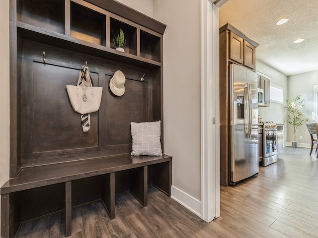 mudroom featuring dark wood-type flooring and a textured ceiling