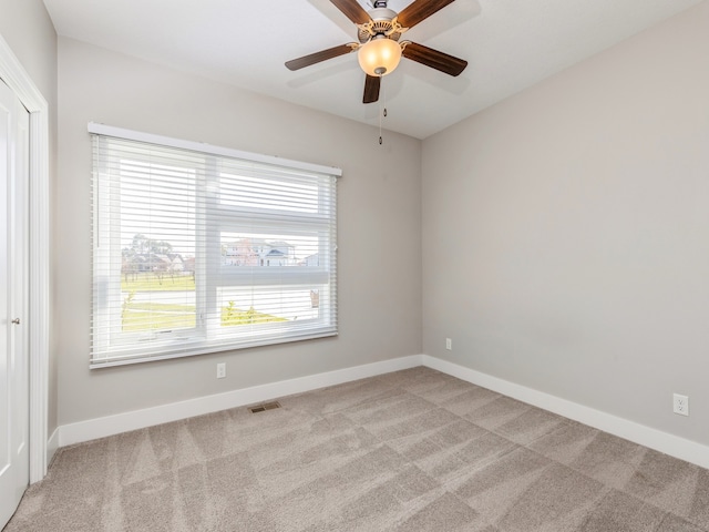 empty room with light colored carpet and ceiling fan