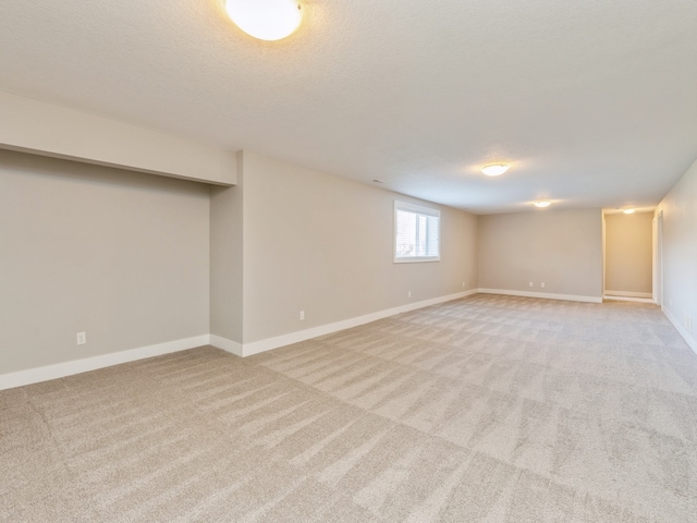 basement with a textured ceiling and light carpet