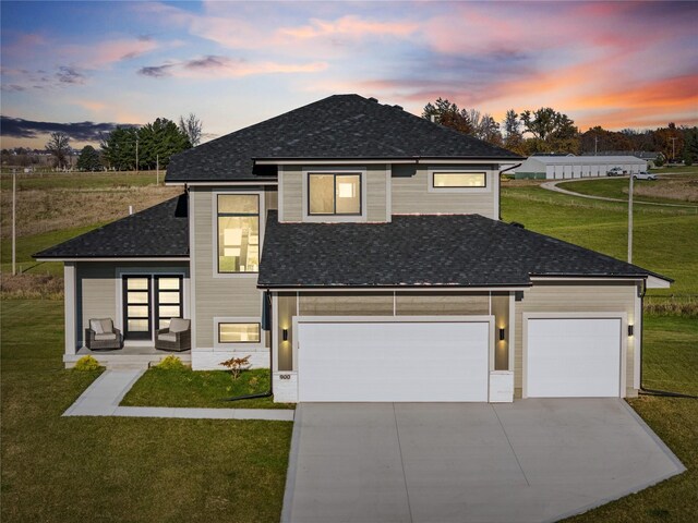 view of front of home with a garage and a yard