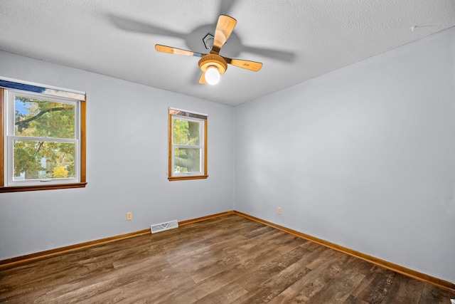 spare room with a healthy amount of sunlight, wood-type flooring, and a textured ceiling