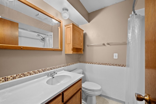 bathroom featuring a shower with curtain, tile patterned floors, toilet, vanity, and tile walls