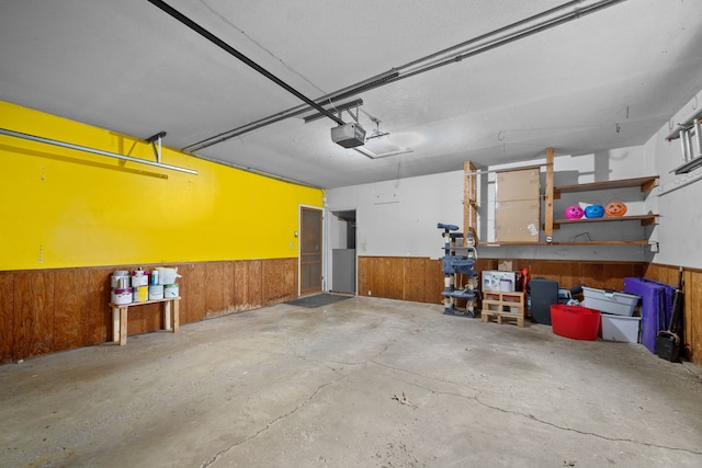 garage with wooden walls and a garage door opener