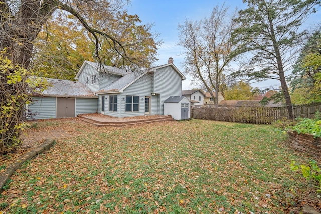 back of house featuring a storage unit and a lawn