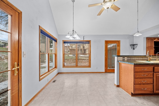 kitchen featuring sink, ceiling fan with notable chandelier, pendant lighting, and vaulted ceiling