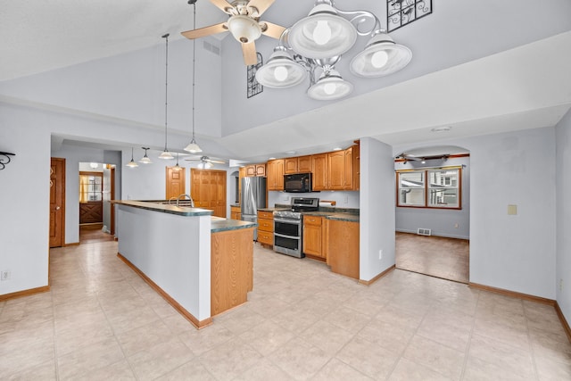 kitchen with ceiling fan, high vaulted ceiling, an island with sink, pendant lighting, and appliances with stainless steel finishes