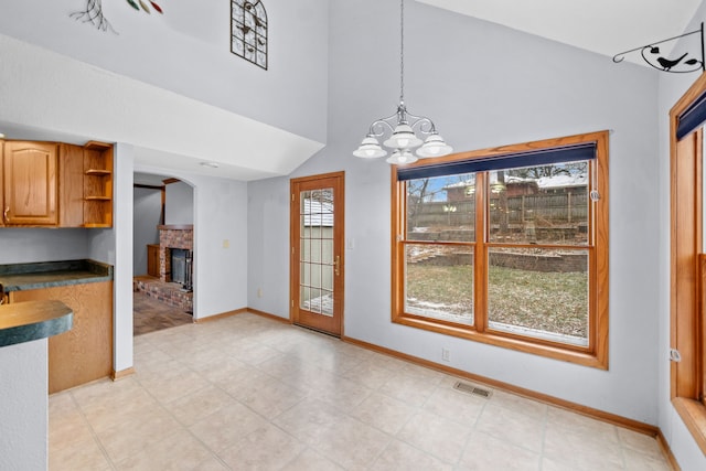 kitchen featuring a fireplace, pendant lighting, and a chandelier