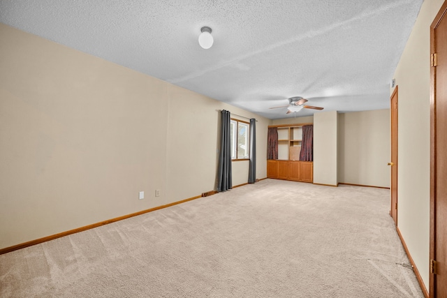 unfurnished room featuring light carpet, a textured ceiling, and ceiling fan