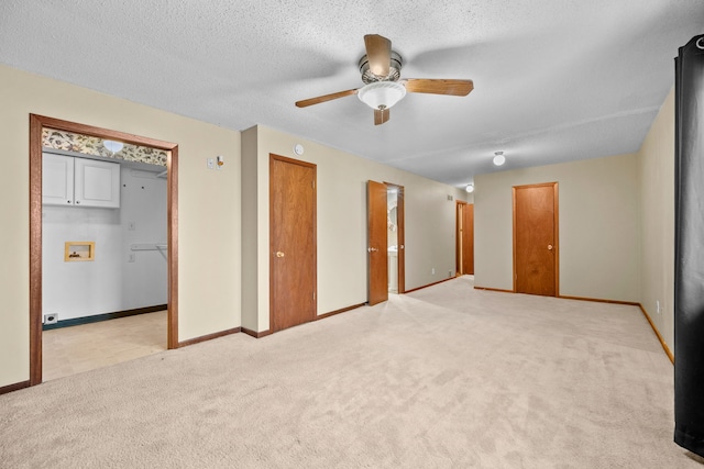 empty room with light carpet, a textured ceiling, and ceiling fan