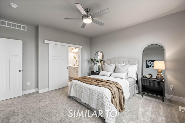 carpeted bedroom with connected bathroom and ceiling fan