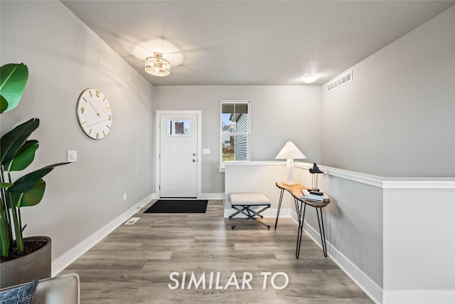 foyer featuring wood-type flooring and a chandelier