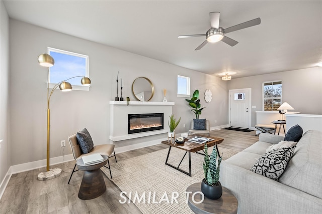 living room featuring a wealth of natural light, wood-type flooring, and ceiling fan