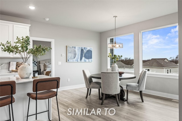 dining area with a chandelier and light hardwood / wood-style flooring