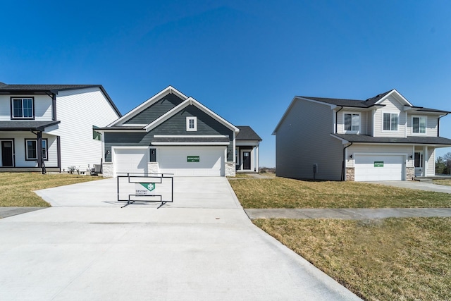craftsman-style home featuring stone siding, driveway, and a front lawn