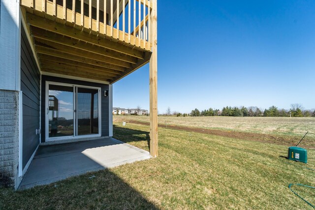 view of green lawn featuring a patio area and a view of countryside