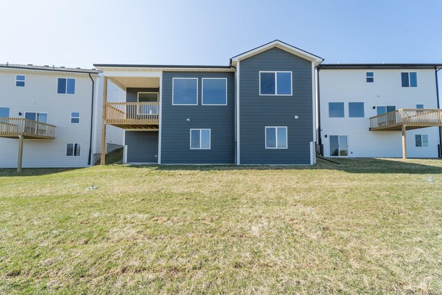 rear view of house with a yard and a balcony