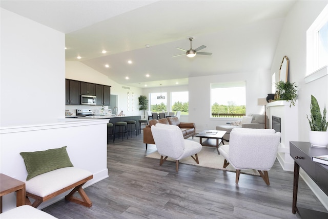 living room featuring a ceiling fan, recessed lighting, wood finished floors, a glass covered fireplace, and high vaulted ceiling