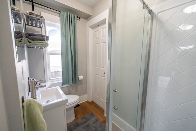 1215 21st St, Des Moines, IA 50311 - full bath featuring wood finished floors, toilet, a shower stall, and vanity