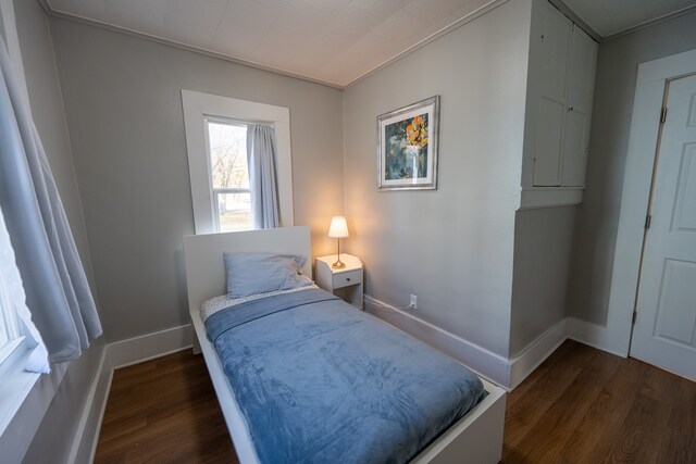bedroom featuring baseboards and wood finished floors