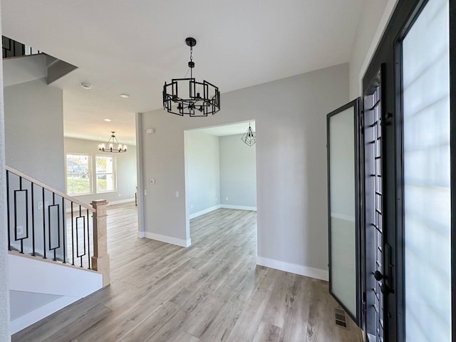 entrance foyer with light wood-type flooring and a chandelier