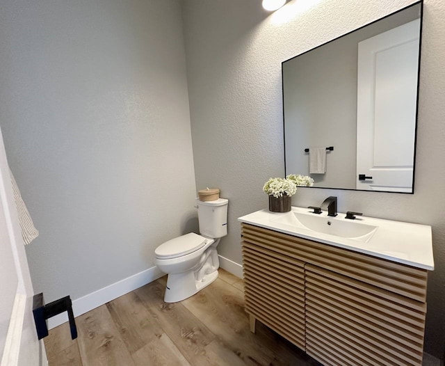 bathroom featuring toilet, vanity, and hardwood / wood-style flooring