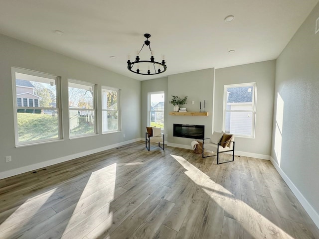 living area featuring light hardwood / wood-style flooring, a chandelier, and plenty of natural light