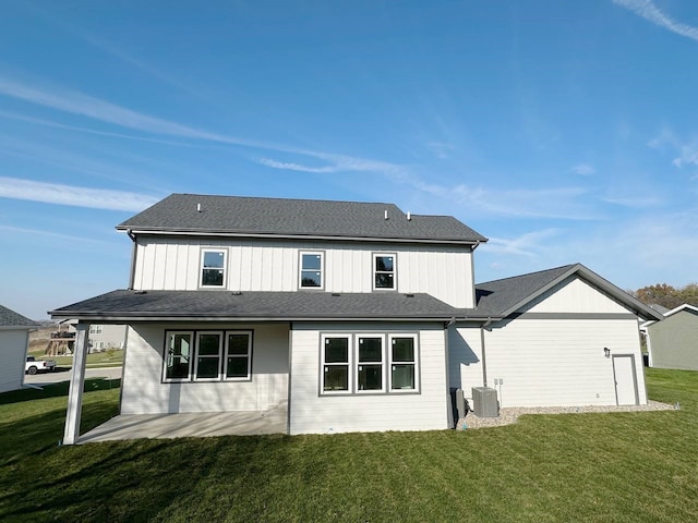 back of property featuring central air condition unit and a lawn