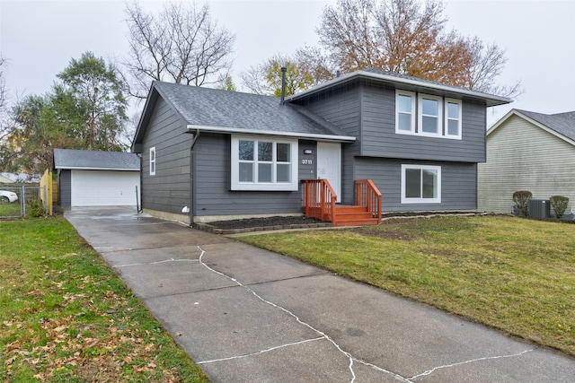 tri-level home featuring central air condition unit, a front lawn, an outdoor structure, and a garage