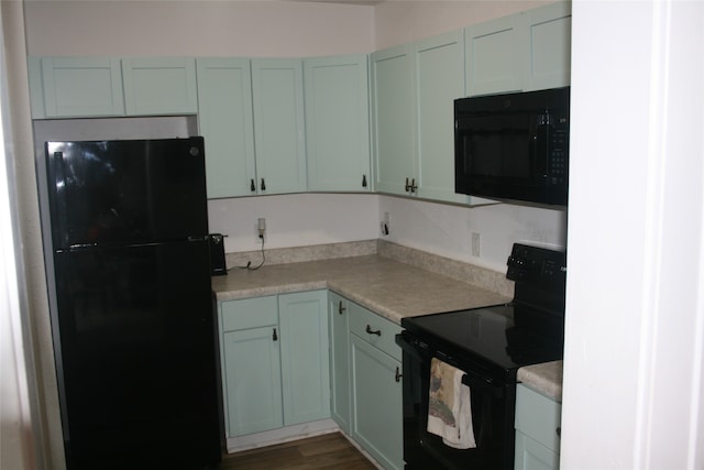 kitchen featuring black appliances and dark hardwood / wood-style flooring