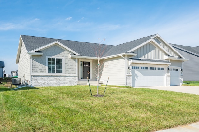 view of front of property featuring central AC unit, a front yard, and a garage