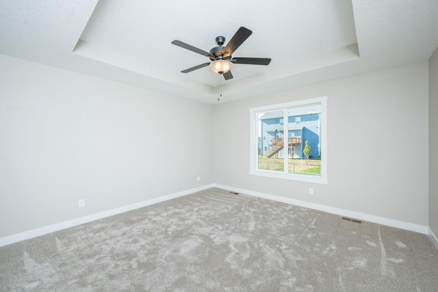 2640 Abbott Dr, Waukee, IA 50263 - carpeted empty room with a tray ceiling and ceiling fan