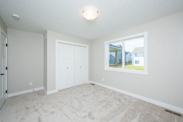 2640 Abbott Dr, Waukee, IA 50263 - unfurnished bedroom with carpet flooring, a closet, and a textured ceiling