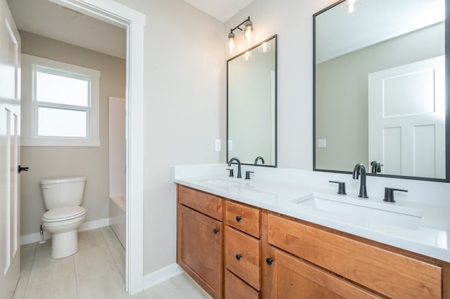 bathroom with toilet, vanity, and tile patterned floors