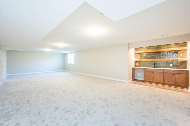 2640 Abbott Dr, Waukee, IA 50263 - unfurnished living room featuring bar with sink and light carpet