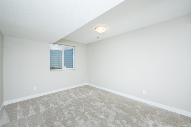 carpeted empty room with a textured ceiling