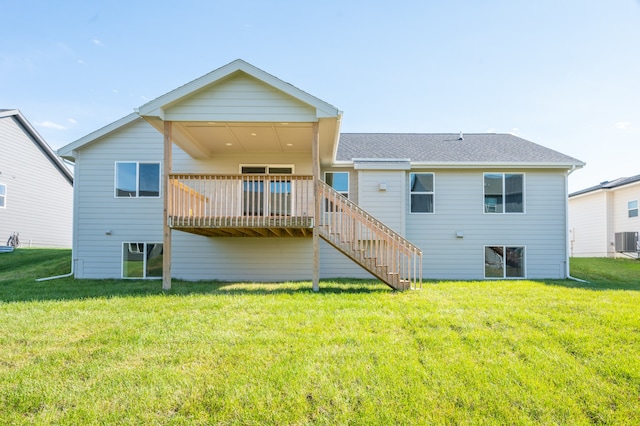 rear view of house with a wooden deck, cooling unit, and a lawn