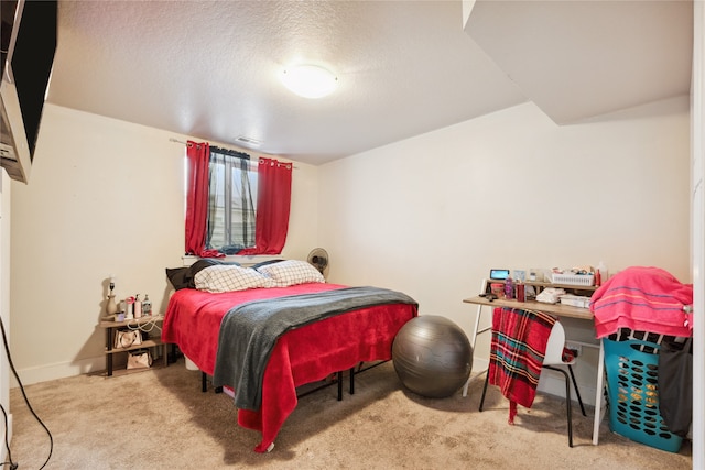 bedroom with a textured ceiling and light carpet