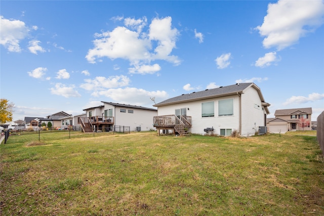 back of property featuring central AC unit, a wooden deck, and a yard