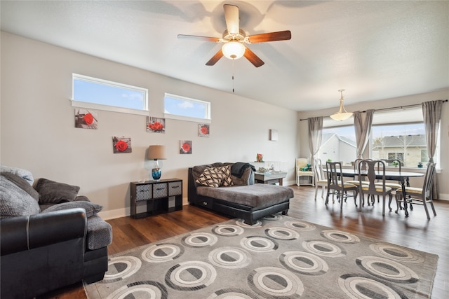 living room with ceiling fan, a wealth of natural light, and dark hardwood / wood-style floors