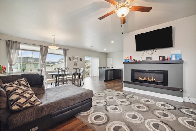 living room featuring dark wood-type flooring, ceiling fan, plenty of natural light, and sink