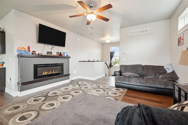 living room with ceiling fan, a wealth of natural light, and dark hardwood / wood-style floors