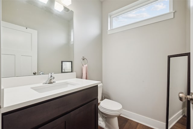 bathroom with wood-type flooring, toilet, and vanity