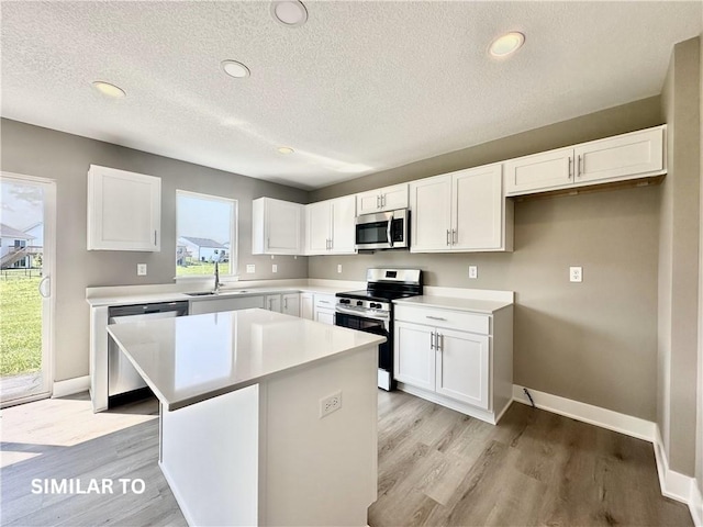 kitchen with a center island, white cabinetry, and appliances with stainless steel finishes