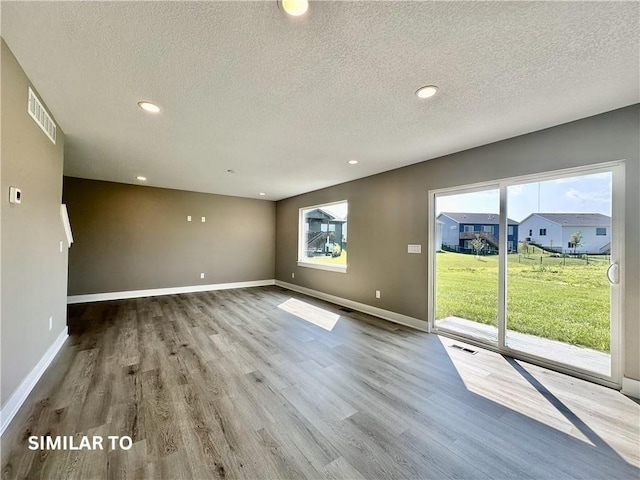 unfurnished room featuring a textured ceiling and hardwood / wood-style flooring